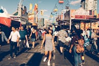 这是一个热闹的街头节日，人们沐浴在明媚的阳光下，欣赏着远处的摩天轮