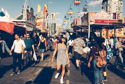 这是一个热闹的街头节日，人们沐浴在明媚的阳光下，欣赏着远处的摩天轮