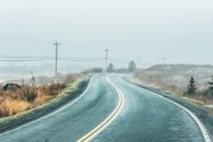 薄雾弥漫的乡村道路上，电线在雾天中若隐若现，非常适合旅行主题