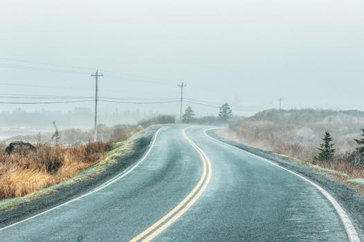 薄雾弥漫的乡村道路上，电线在雾天中若隐若现，非常适合旅行主题