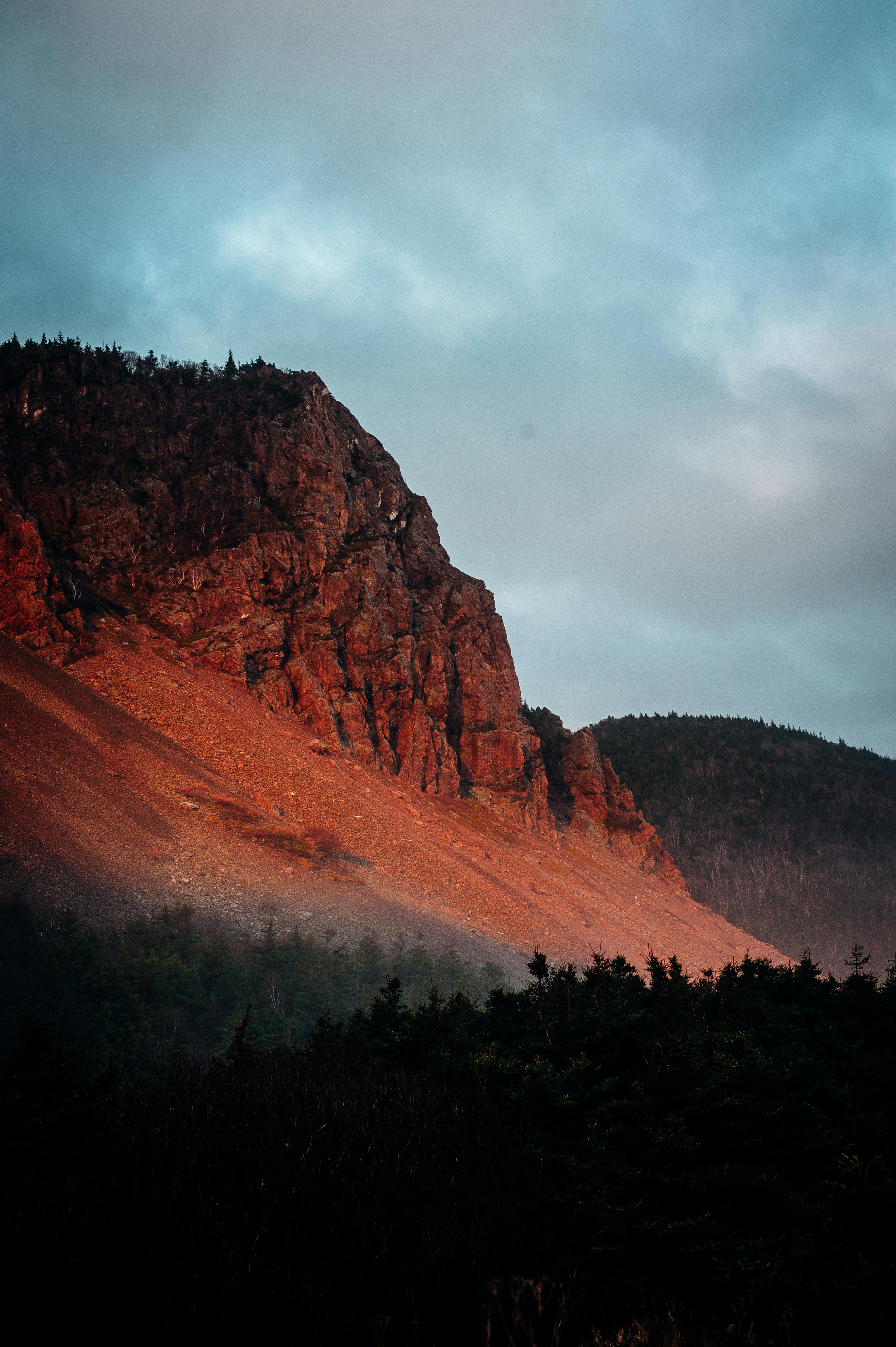 温暖的日落色调照亮了令人惊叹的岩石山脉景观