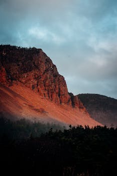 温暖的日落色调照亮了令人惊叹的岩石山脉景观