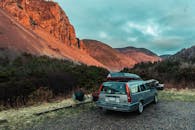 汽车旁有个轻松的露营地，坐拥山景，头顶是充满活力的天空