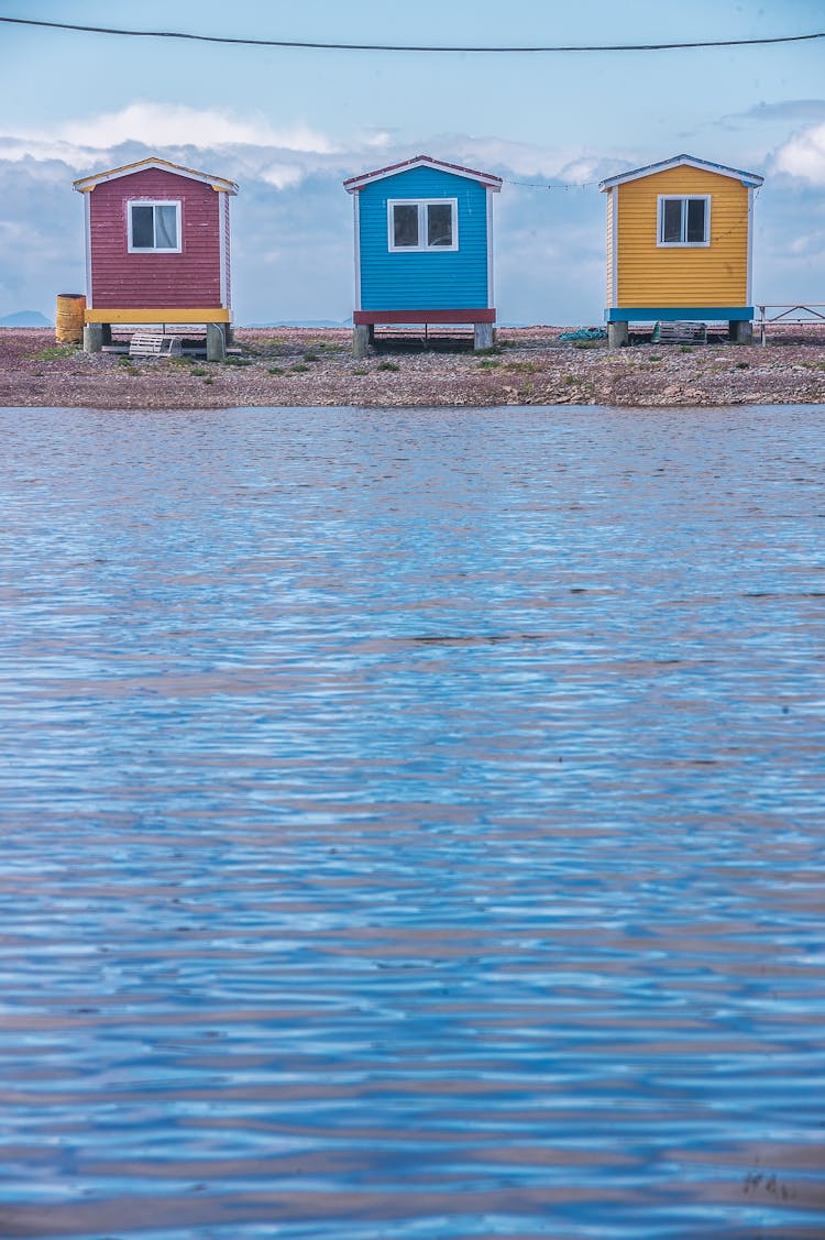 Three Assorted-color Wooden Mini Houses Facing Sea