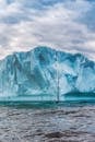 在多云的天空下，一个宁静的冰山漂浮在平静的水域的壮丽景色