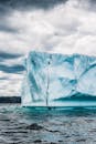 在多云的天空下，海洋中冰山的惊人照片，展示了大自然的冰冻之美