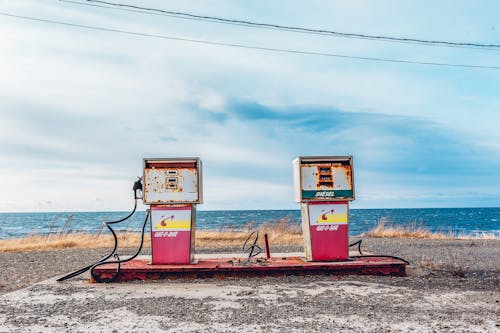 無料 海の近くの白とピンクのガソリンスタンド 写真素材