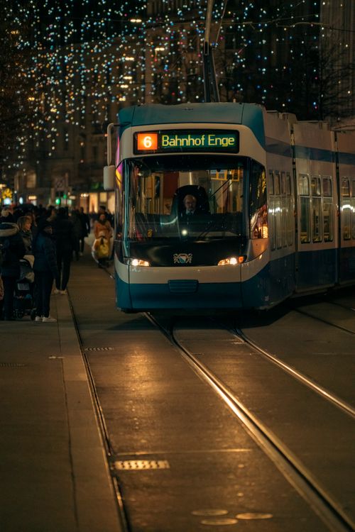 Free Tram number 6 heading to Bahnhof Enge on a city street at night. Stock Photo