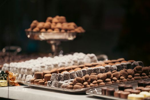 Assorted chocolate truffles presented elegantly on trays in a store display.