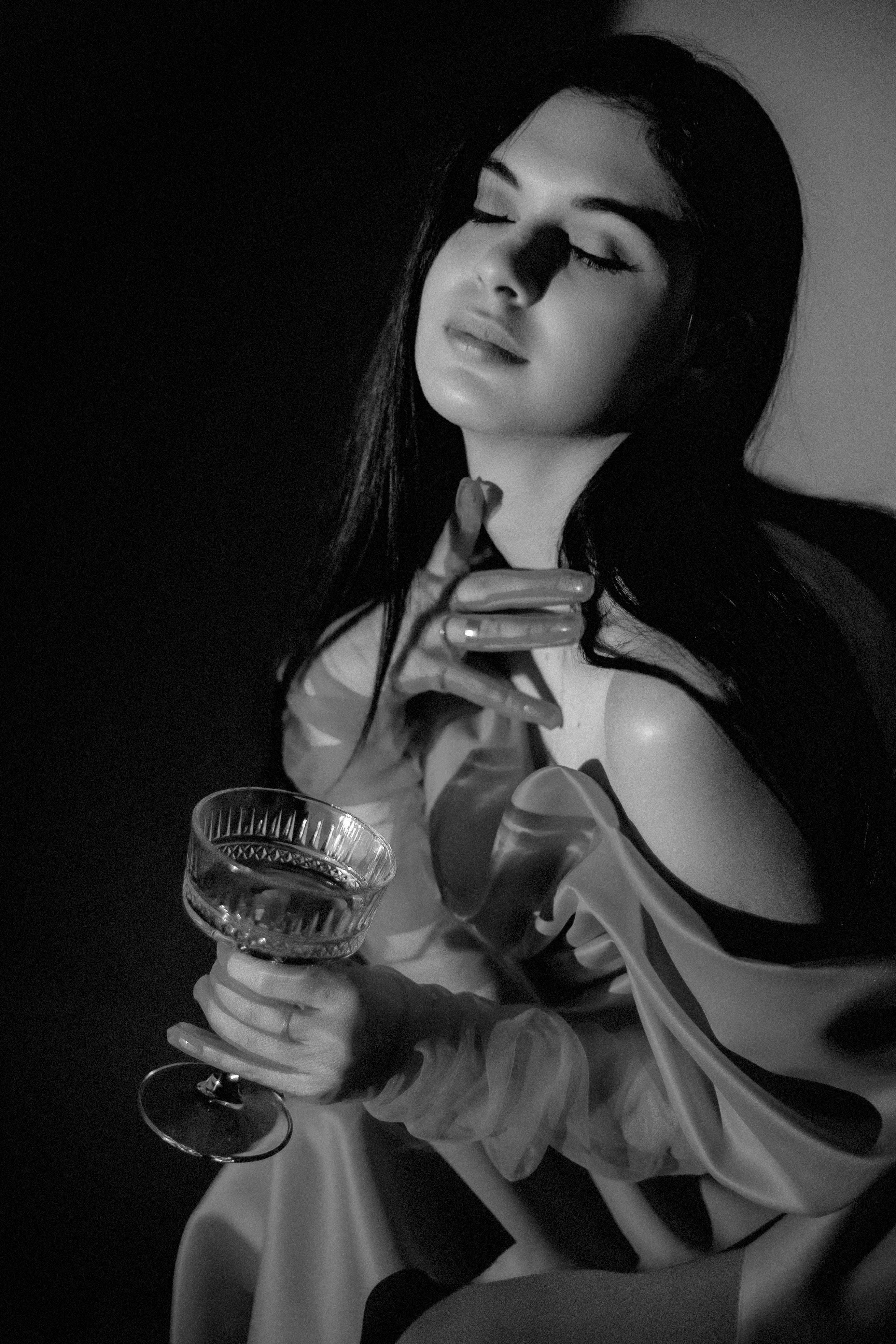 Black and white portrait of a woman enjoying a moment with a wine glass.