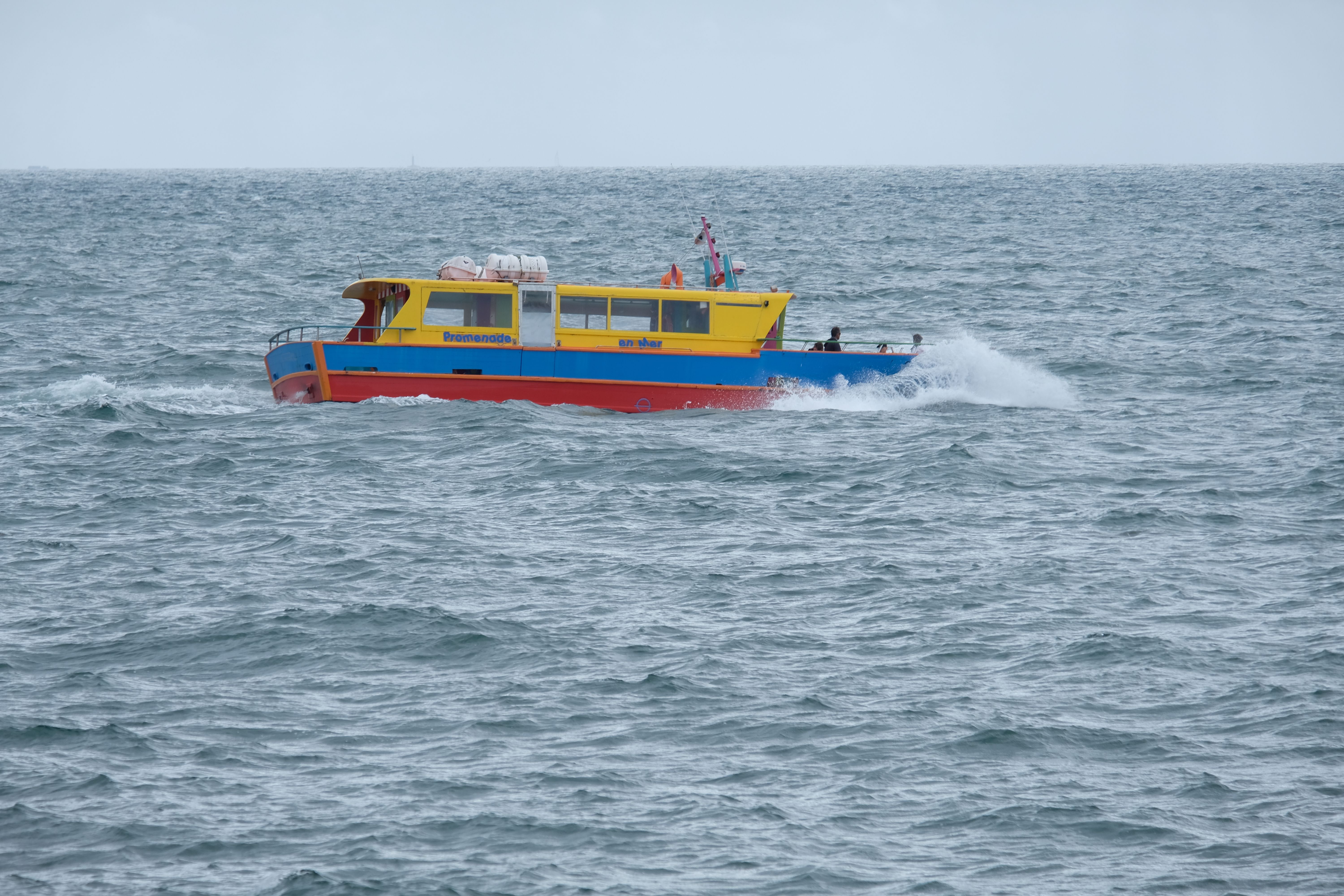 Vibrant motorboat cruising the open sea, ideal for tourists' ocean adventures.