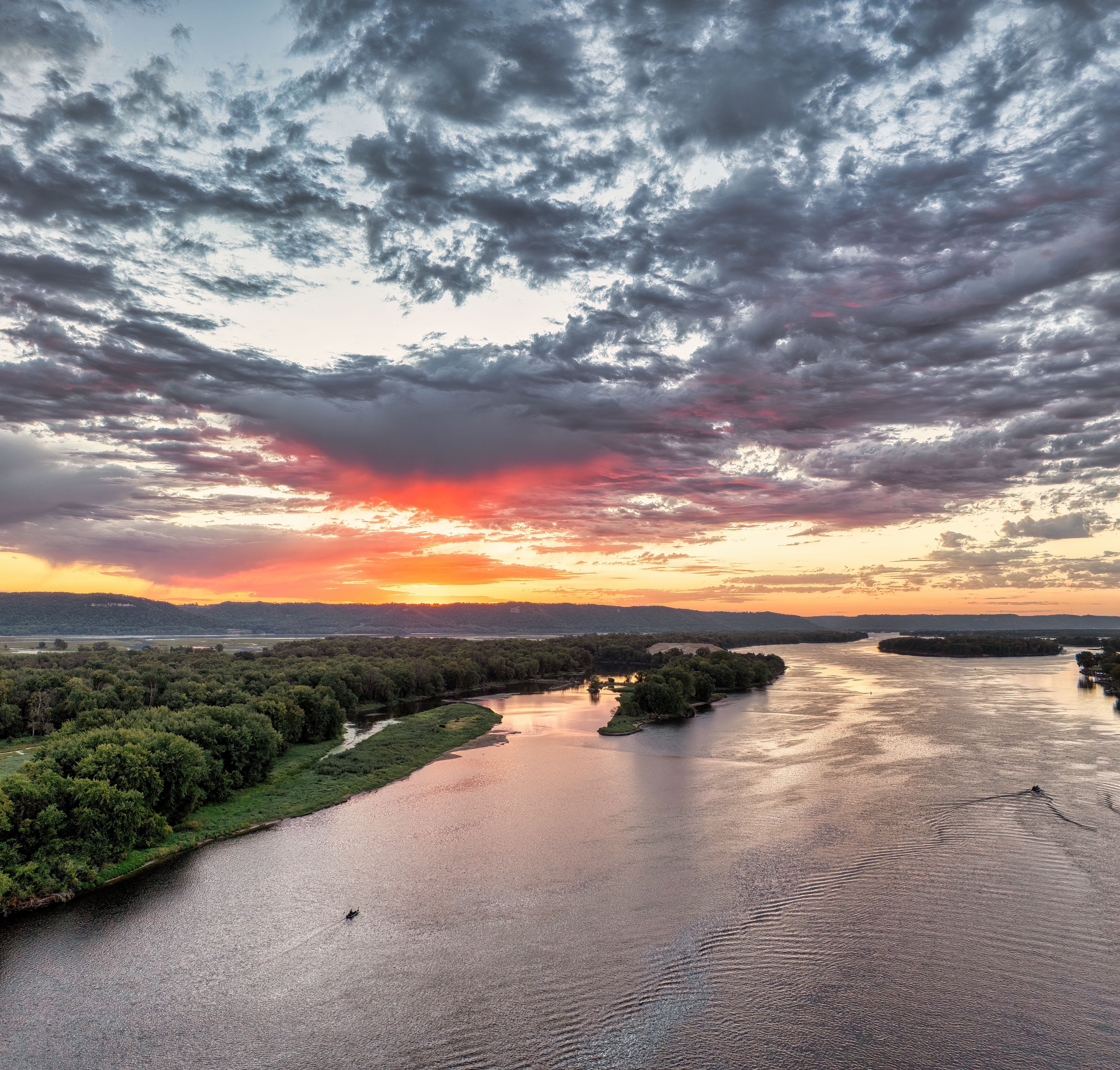 A stunning aerial view capturing the sunset over the Mississippi River in Wabasha, MN, with dramatic clouds.