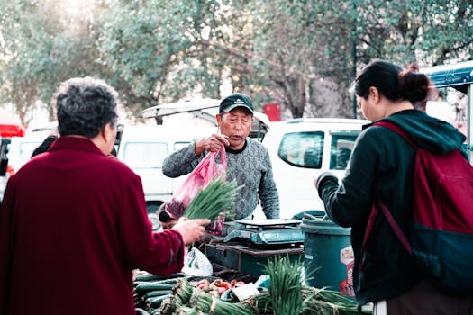 Outdoor market scene capturing vibrant interactions between vendors and shoppers exchanging fresh produce.