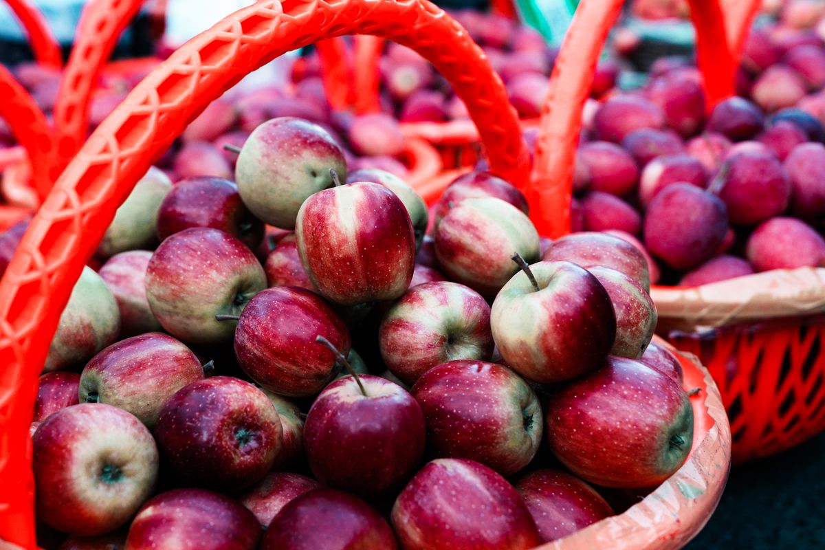 Baskets overflowing with fresh red apples at an outdoor market, symbolizing an abundance money mindset
