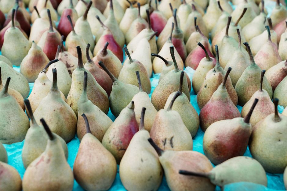Vibrant arrangement of ripe pears at a farmer's market.