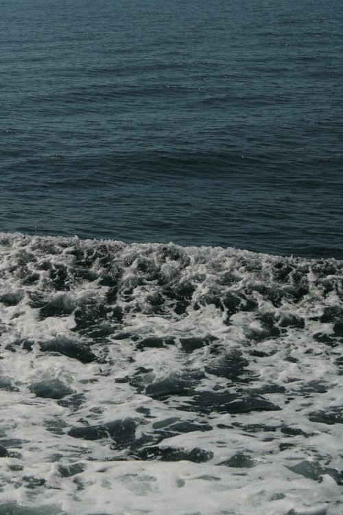Free A dramatic view of ocean waves crashing against the shoreline, capturing the dynamic energy of the sea. Stock Photo