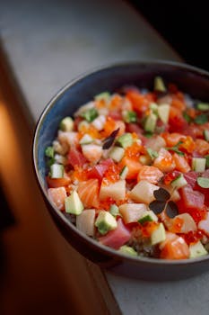 Colorful poke bowl with fresh salmon, tuna, avocado, and rice.