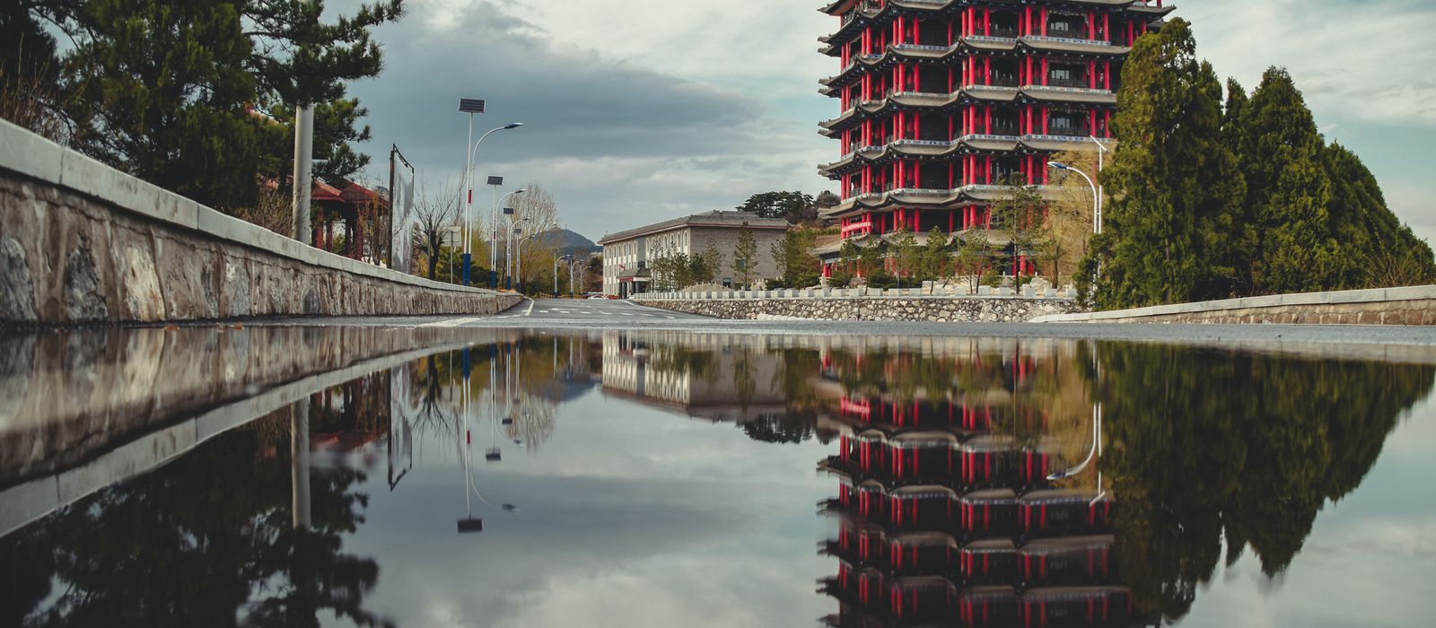Stunning view of a traditional pagoda in Taiyuán, reflecting in a puddle on a cloudy day. — flights from Beijing to Taiyuan