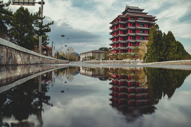 Stunning view of a traditional pagoda in Taiyuán, reflecting in a puddle on a cloudy day.