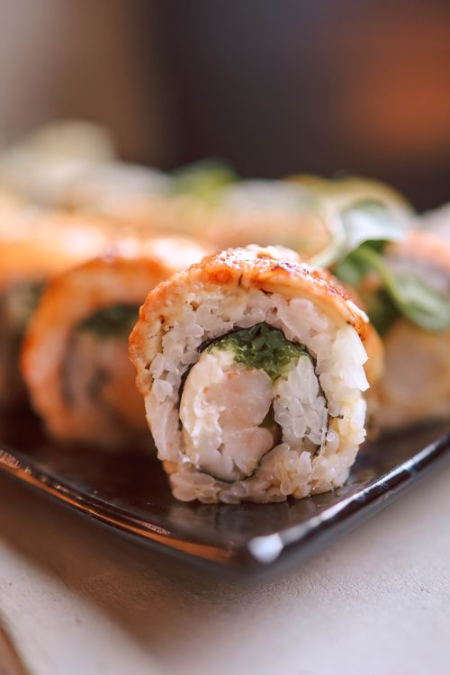Free Fresh sushi roll delicately wrapped with shrimp and avocado, beautifully presented. Stock Photo