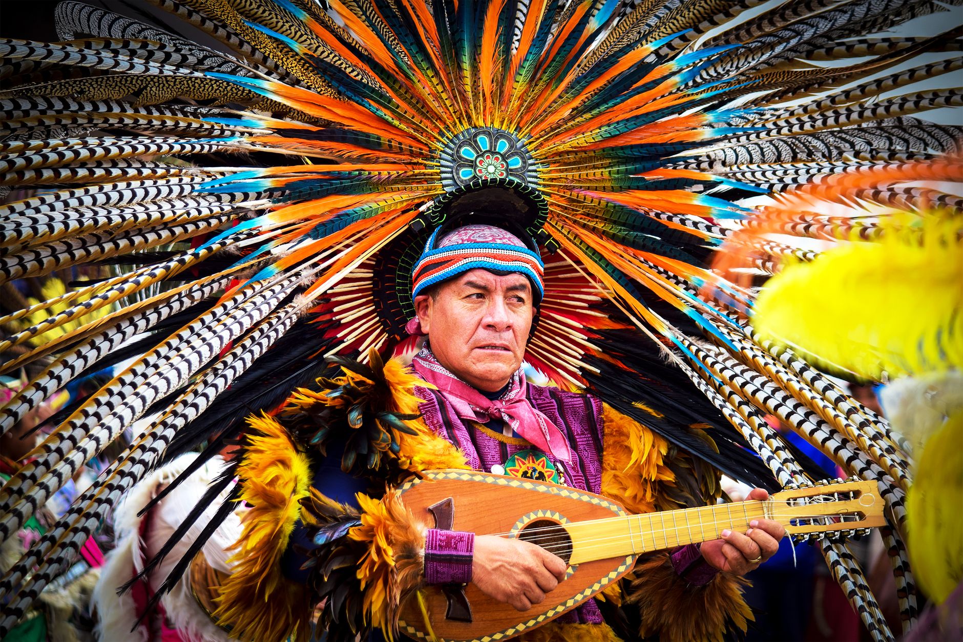 Traditional Aztec ceremonial dance with vibrant feathered headdress in Atlacomulco, Mexico.