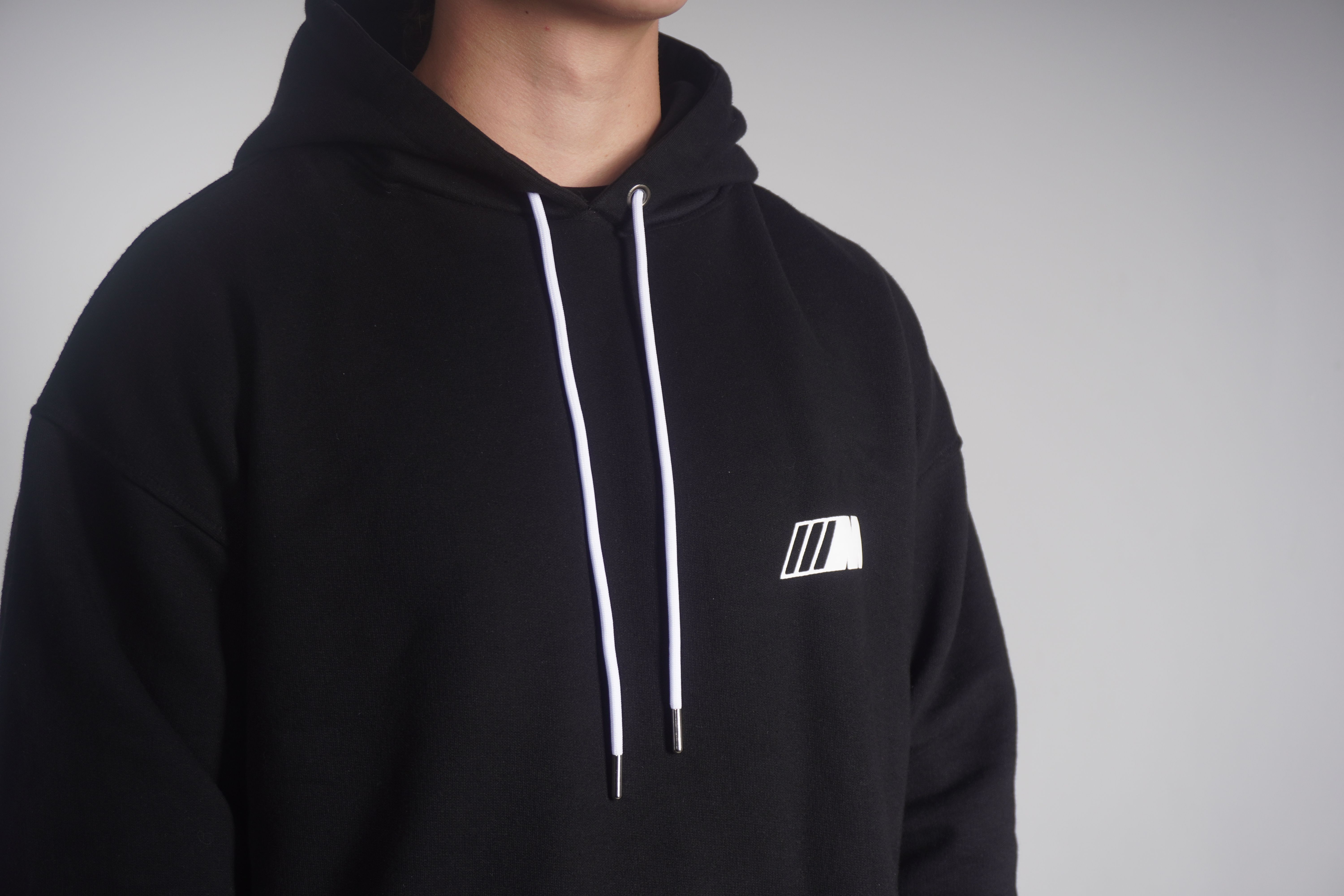 Détail d'un ensemble streetwear composé d'un hoodie et de vêtements premium assortis.