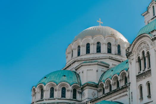 The iconic domes of Alexander Nevsky Cathedral against a clear blue sky in Sofia, Bulgaria.