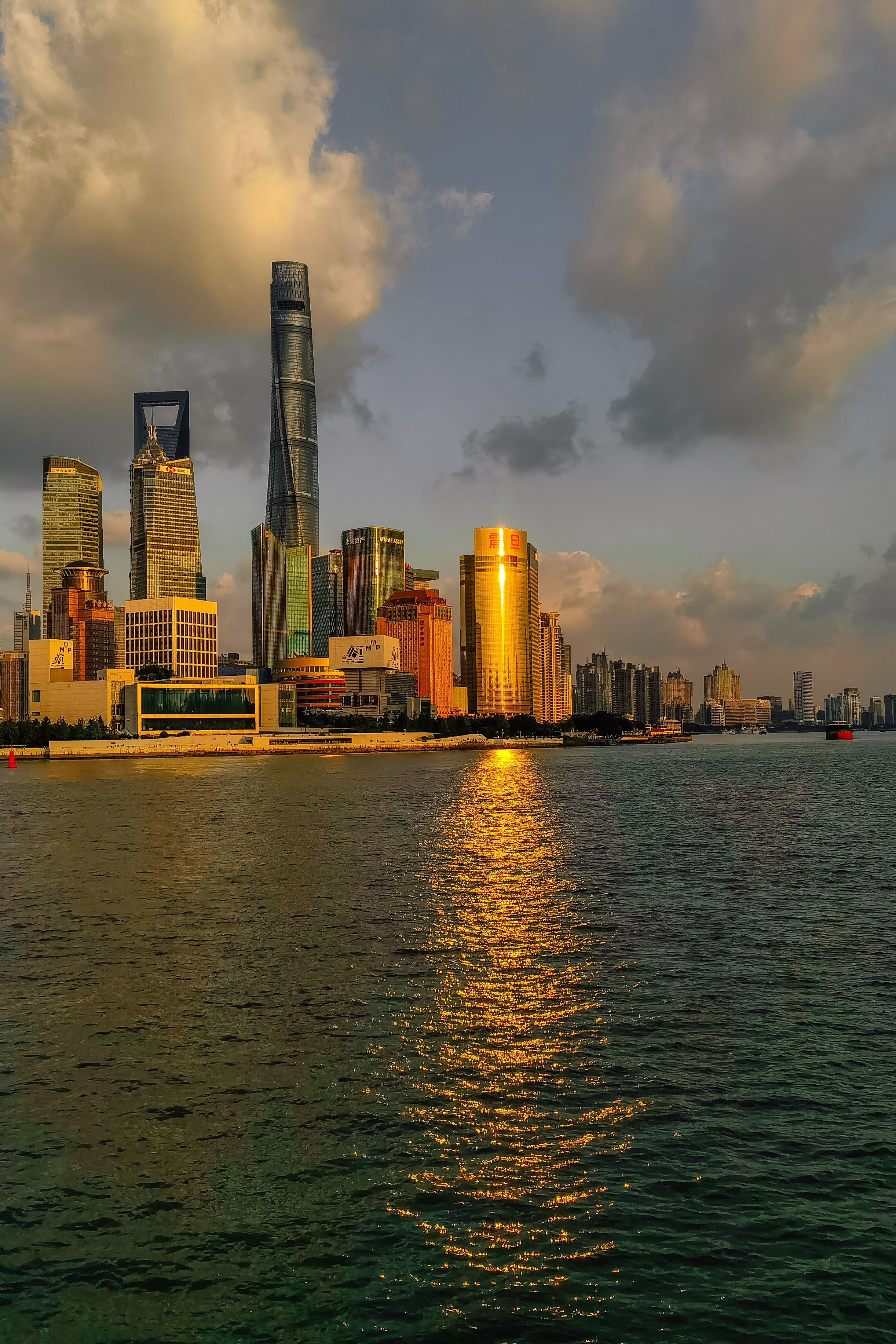 The Shanghai skyline at sunset, golden light on the Huangpu