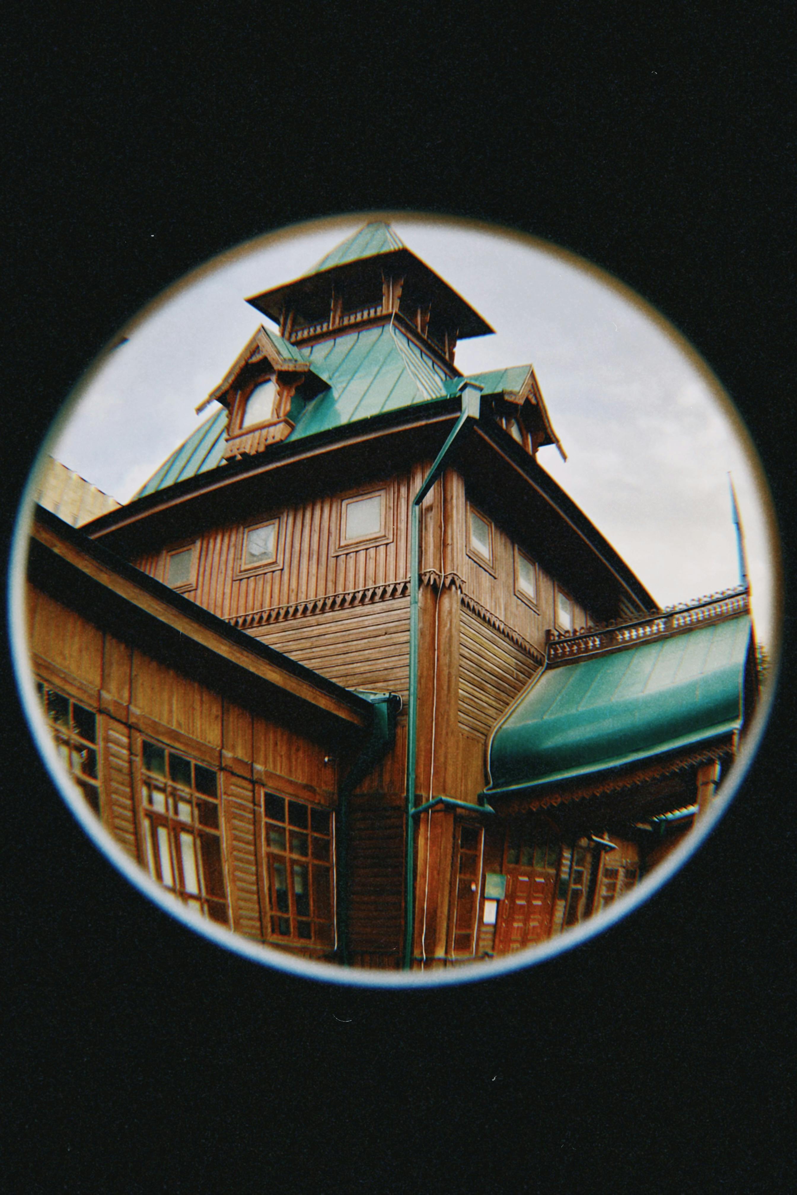 Explore Almaty's architectural charm through a fisheye lens showcasing a historic wooden house.