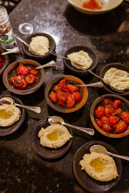 Free A top view of various dips and roasted tomatoes in bowls on a dark table. Stock Photo
