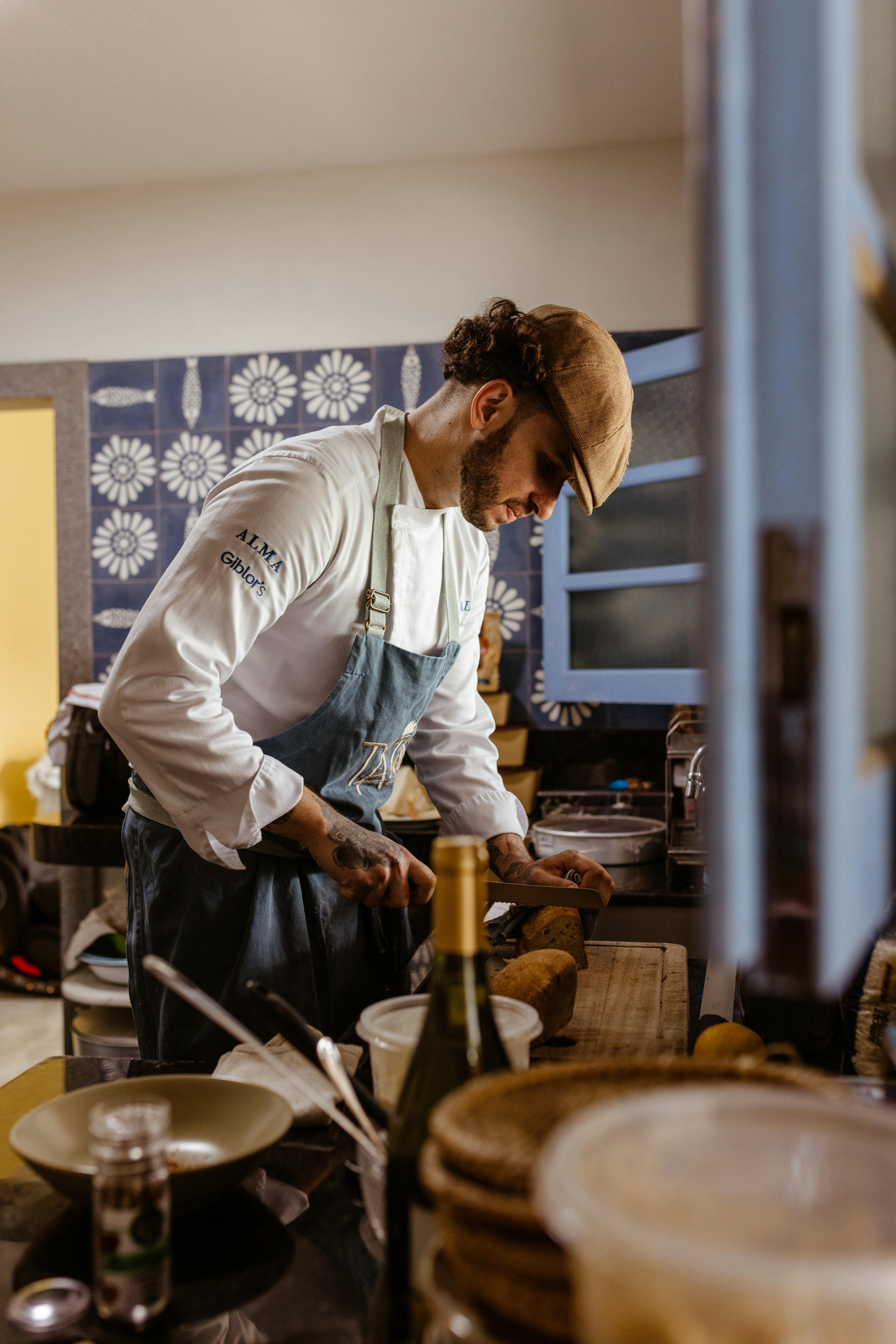 Chef in apron skillfully preparing a dish in a cozy, warmly lit kitchen ambiance.