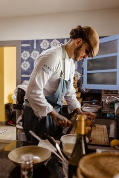 Chef concentrating on preparing a gourmet dish in a stylish kitchen setting.