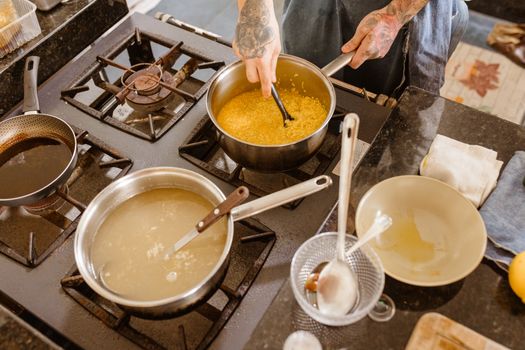 Professional chef stirring ingredients on a gas stove in a modern kitchen setting, showcasing skillful culinary preparation.