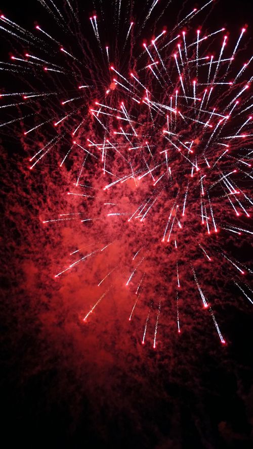 Free Vibrant red and white fireworks illuminate the night sky in Reus, Spain. Stock Photo
