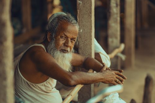 Free Portrait of an elderly man in Dhaka, Bangladesh, sitting thoughtfully outdoors. Stock Photo