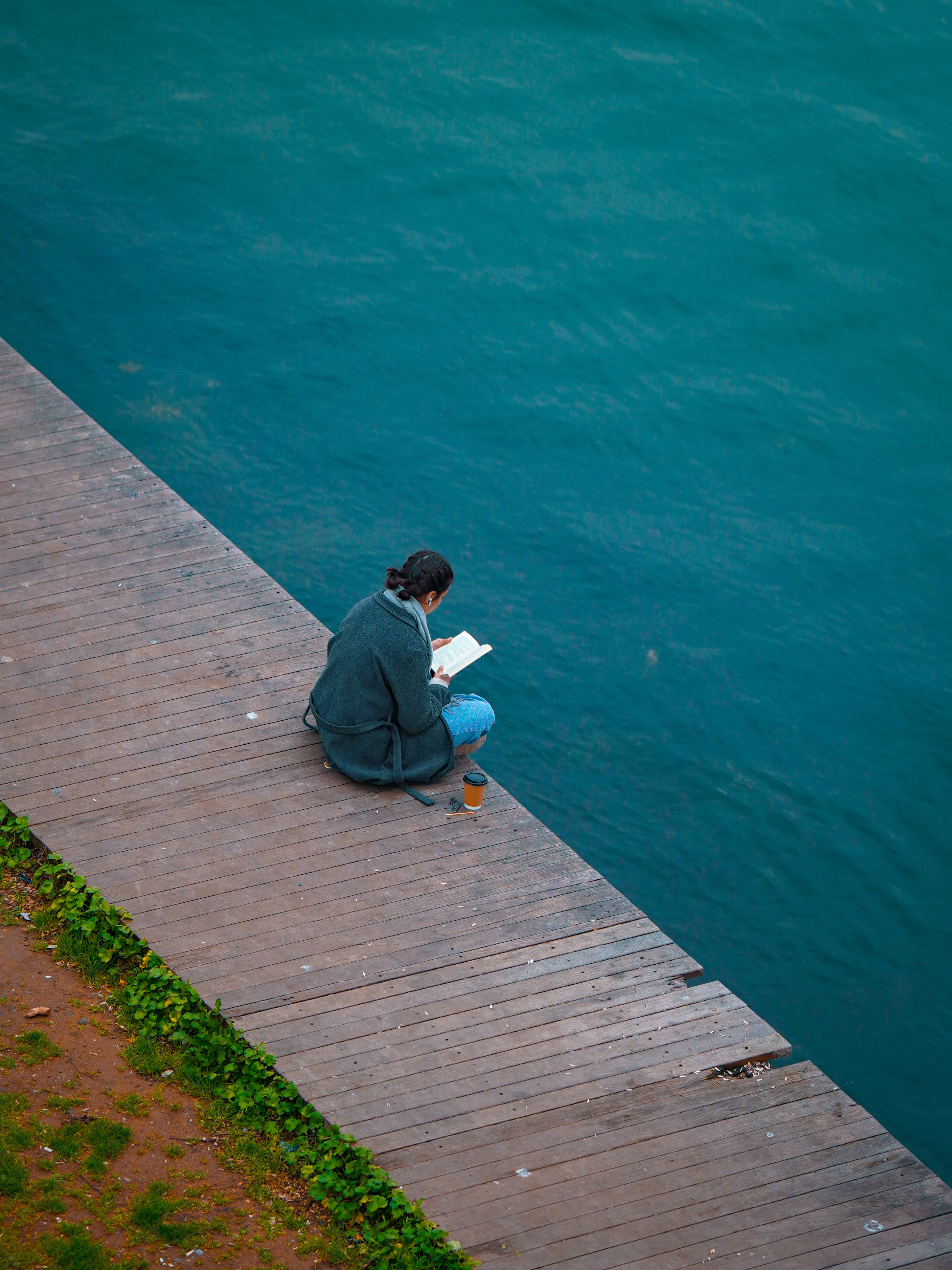 Capturing tranquility as a person reads by the vibrant water in Istanbul.