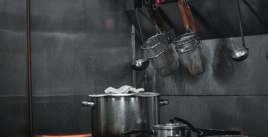 A stainless-steel commercial kitchen — F&B premises are quoted by floor area and pest risk