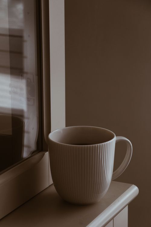 Free Warm coffee mug on window sill, creating a serene morning vibe. Stock Photo