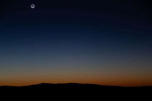 Free Crescent moon over East Wenatchee skyline at twilight, capturing serene natural beauty. Stock Photo