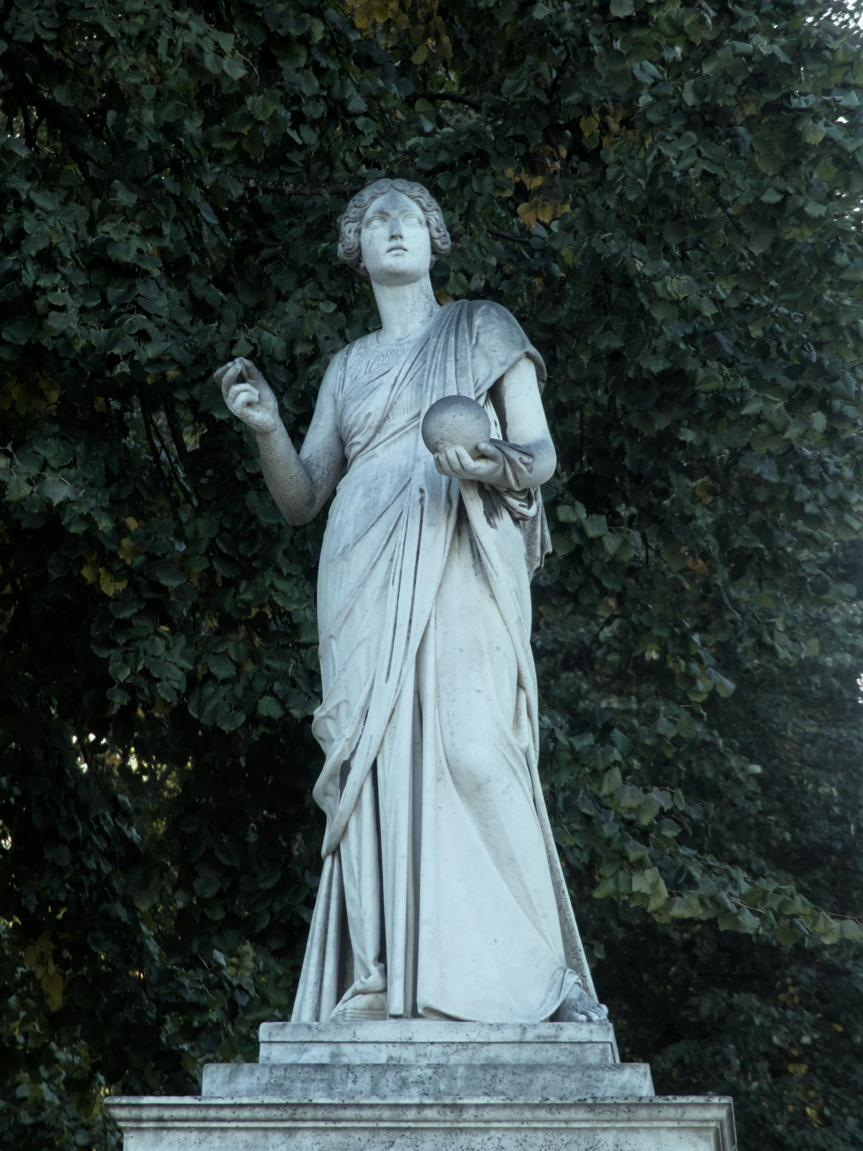 Elegant marble statue in a lush outdoor setting in Potsdam, Germany.
