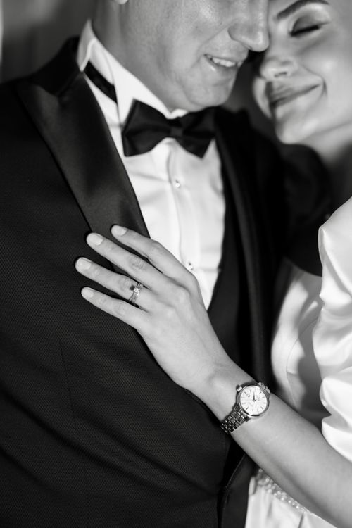 Free Close-up black and white photo of an elegant couple embracing, showcasing a watch and wedding ring. Stock Photo