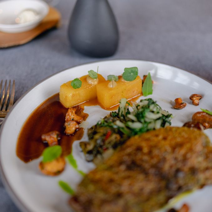 A plated main of braised meat with potatoes and greens — photo by Filipp Romanovski on Pexels