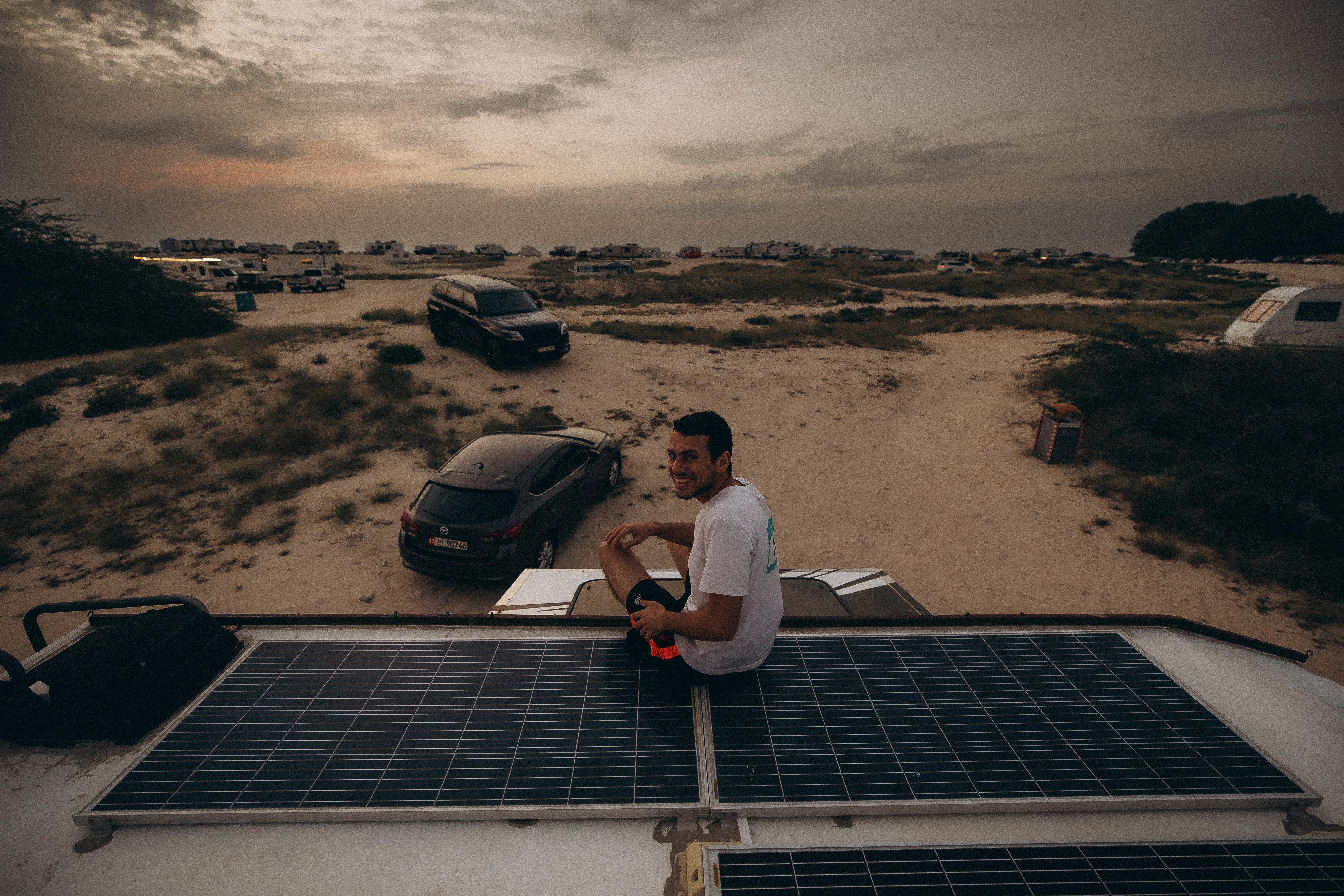 Free Explore the serene desert landscape in Dubai at sunset with camping and solar panels. Stock Photo