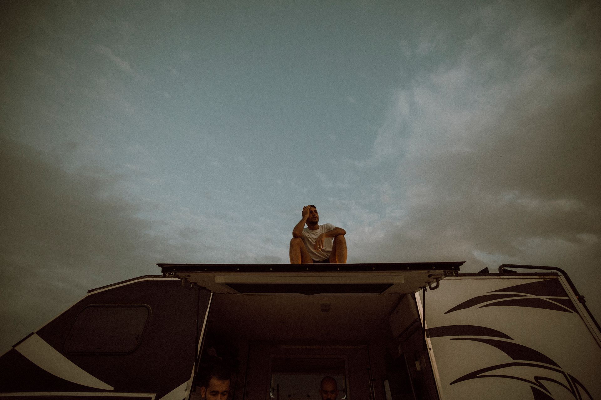 Adventurous Man Sitting on Rooftop of RV in Dubai