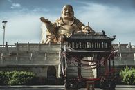 山西省太原市一座中国传统寺庙外，矗立着一尊雄伟的金佛雕像