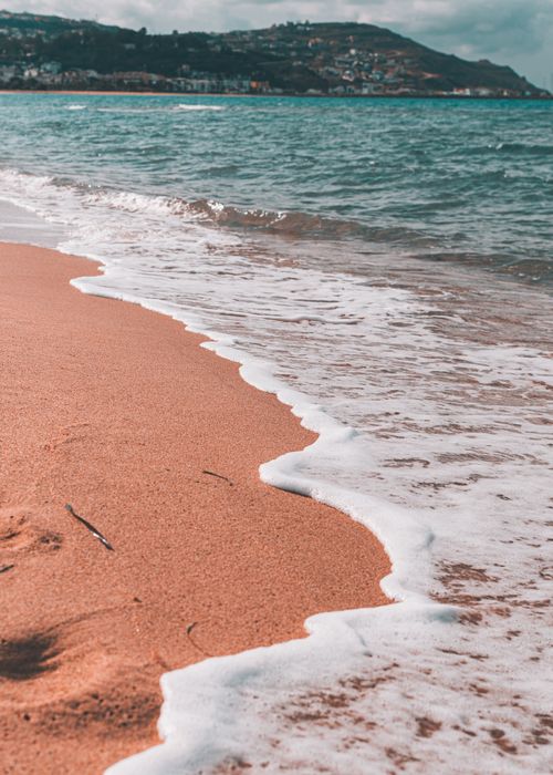 Free Relaxing beach view with waves and coastline in Tabarka, Tunisia at sunset. Stock Photo