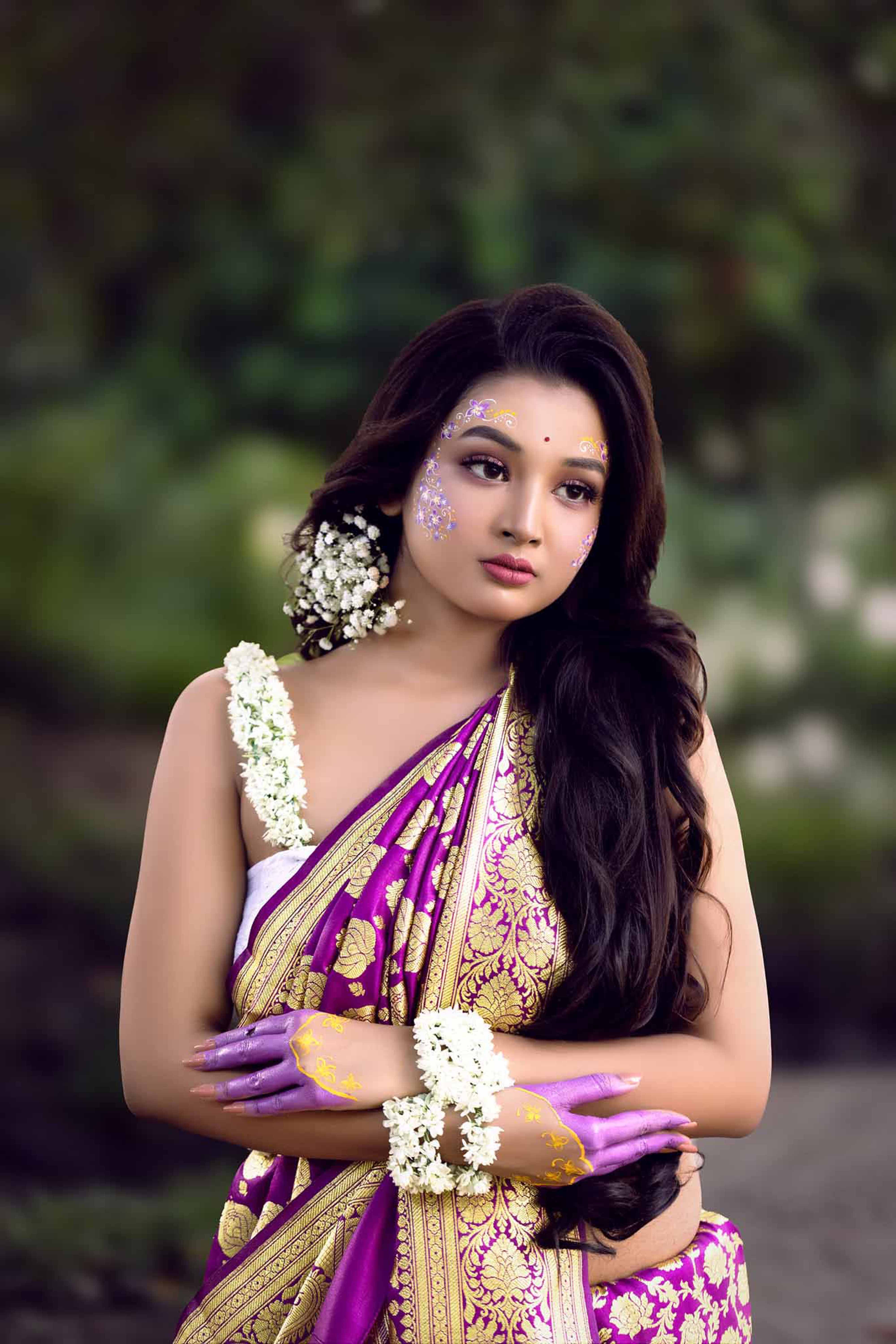 Elegant portrait of a woman in a colorful saree with intricate designs.