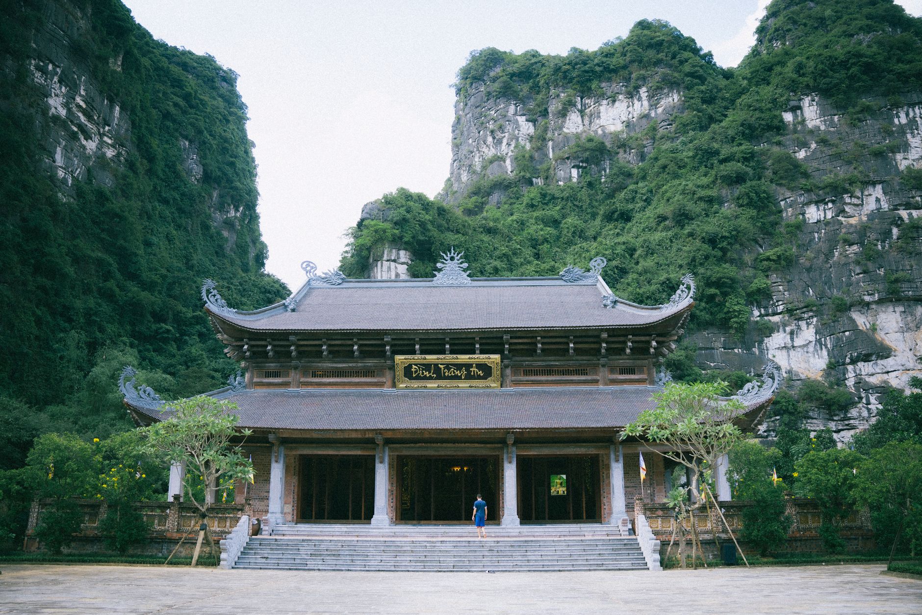 A serene view of a traditional pagoda in Ninh Bình, surrounded by lush green hills.