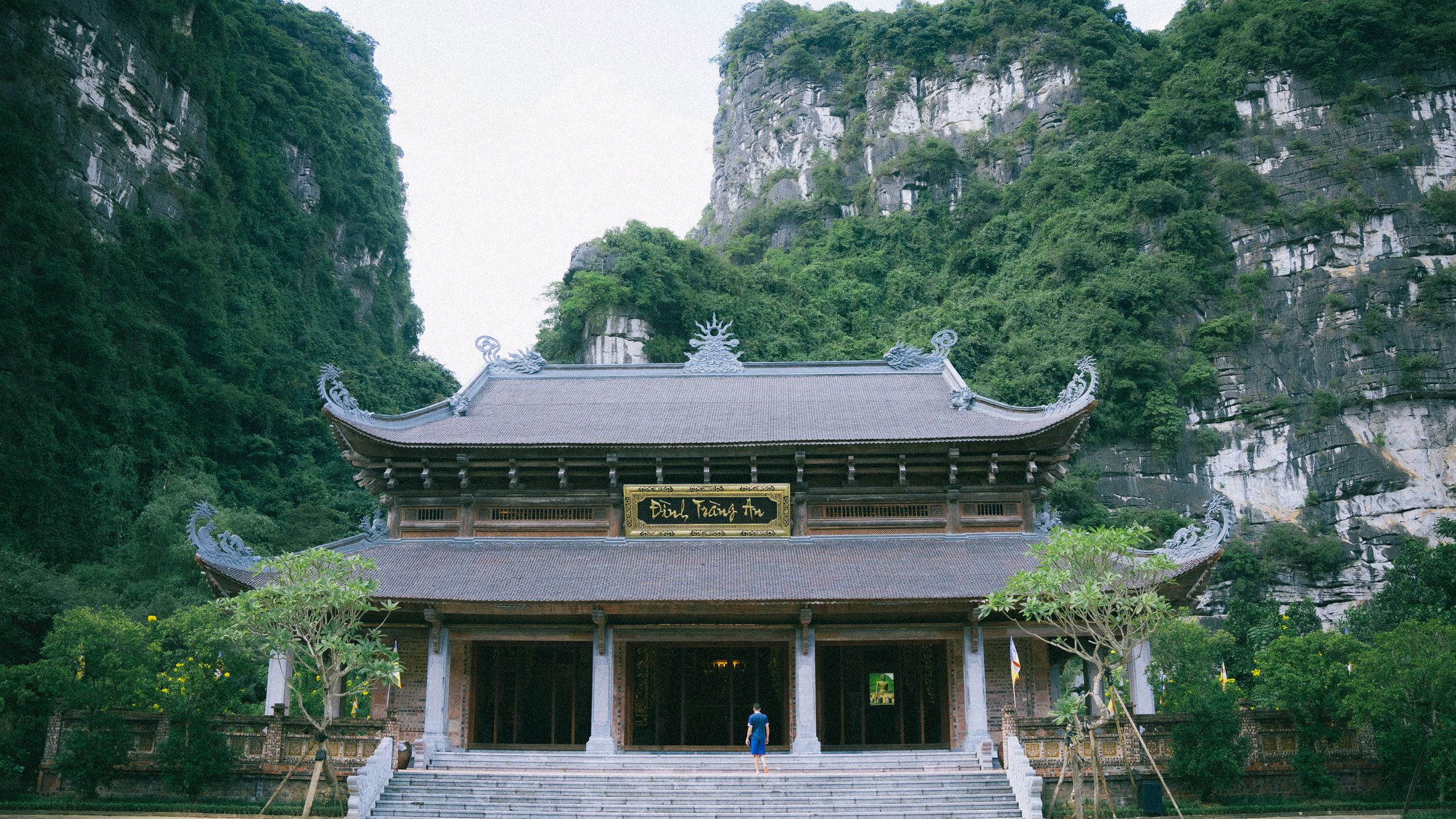 A serene view of a traditional pagoda in Ninh Bình, surrounded by lush green hills.