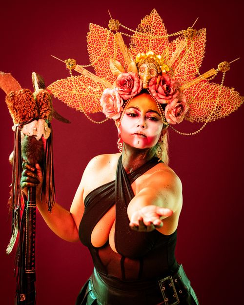 Free Dramatic portrait of a woman in elaborate headdress offering her hand. Stock Photo